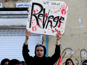 An Iranian mourner holds a placard during the final stage of funeral processions for slain top general Qasem Soleimani, in his hometown Kerman on January 7, 2020. (AFP/ File Photo)