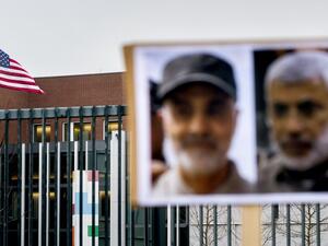 A picture shows the US flag and portraits of Iranian commander Qasem Soleimani (L) and Iraq's Hashed al-Shaabi military network deputy chief Abu Mahdi al-Muhandis, both killed in Baghdad early on January 3, 2020, by a US airstrike, as seen on a protesters' placard outside the US Embassy in The Hague on January 7, 2020. Koen Van WEEL / ANP / AFP