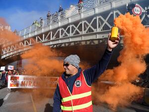 A man holds a smoke grenade as he takes part in a demonstration against the pension reform in Marseille, on January 9, 2020. (AFP/ File Photo)