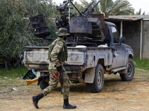 A fighter loyal to the internationally recognised Libyan Government of National Accord (GNA) walks past a vehicle in an area south of the Libyan capital Tripoli on January 12, 2020. (AFP/ File Photo)