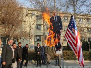 Members of the Basij, a militia loyal to the Islamic republic's establishment, burn a cardboard cutout of Britain's ambassador Rob Macaire along a Union Jack and US flag during a memorial for victims of the Ukraine plane crash, at University of Tehran on January 14, 2020. Iran signalled it could expel Britain's ambassador in case of further "interference" in its affairs after a row over a vigil he attended for those killed in last week's downing of a Ukrainian plane. ATTA KENARE / AFP