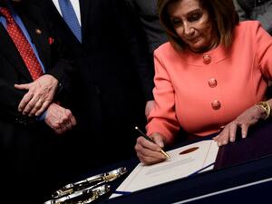 Speaker of the House Nancy Pelosi (D-CA) signs the articles of impeachment of US President Donald Trump during an engrossment ceremony on Capitol Hill January 15, 2020, in Washington, DC. The US House of Representatives voted Wednesday to transmit articles of impeachment against President Donald Trump to the Senate, opening the way for the historic trial of the 45th president for abuse of power. Brendan Smialowski / AFP