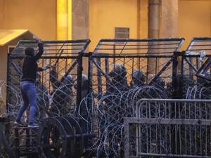 Anti-government protesters attempt to break through the security barrier in the central downtown district of the Lebanese capital Beirut near the parliament headquarters during clashes with security forces on January 18, 2020. ANWAR AMRO / AFP