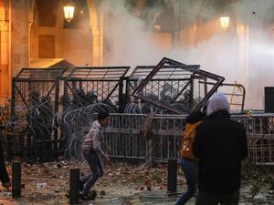 Anti-government protesters attempt to break through the security barrier in the central downtown district of the Lebanese capital Beirut near the parliament headquarters during clashes with security forces on January 18, 2020. ANWAR AMRO / AFP