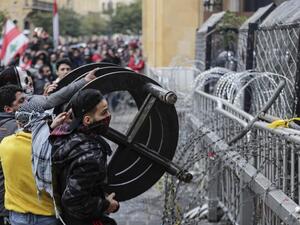 Anti-government protesters attempt to break through the security barrier in the central downtown district of the Lebanese capital Beirut near the parliament headquarters during clashes with security forces on January 18, 2020. ANWAR AMRO / AFP Anti-government protesters attempt to break through the security barrier in the central downtown district of the Lebanese capital Beirut near the parliament headquarters during clashes with security forces on January 18, 2020. ANWAR AMRO / AFP