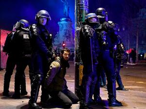 French riot police officers detain a demonstrator on Republic Square (AFP)