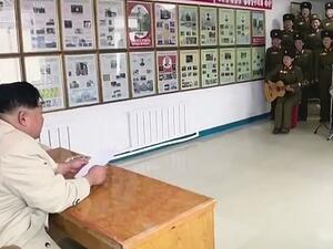 Spectator: North Korean strongman Kim Jong-un sits behind a desk and watches the performance by women in military uniform. (Video Screenshot)