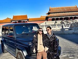 These two Chinese tourists have caused outrage by posing inside the Forbidden City in Beijing with their £100,000 Mercedes G-Wagen. (Facebook)