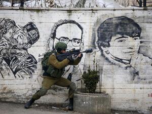 An Israeli soldier fires teargas towards Palestinian demonstrators during a demonstration in al-Aroub Palestinian refugee camp, between the West Bank towns of Hebron and Bethlehem, on January 29, 2020. US President Donald Trump unveiled his controversial Israeli-Palestinian peace deal that staunchly favours Israel but offers Palestinians a pathway to a limited state. HAZEM BADER / AFP