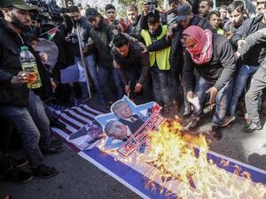 Palestinian demonstrators burn portraits of US President Donald Trump and Israeli Prime Minister Benjamin Netanyahu with the slogan in Arabic "Down with the Deal of the Century" as well as flags of their respective nations during a protest in Gaza's Jabalia refugee camp on January 31, 2020 against a proposed peace plan by the US president. AFP