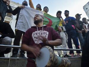 An Algerian protester beats the darbuka while others chant during an anti-government demonstration in the capital Algiers, on January 31, 2020. RYAD KRAMDI / AFP