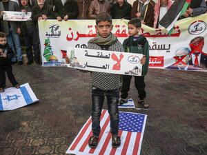 A Palestinian demonstrator takes part in a protest against a US-brokered Middle East peace plan, while holding placard that reads in Arabic "No to the deal of shame", in Rafah in the southern Gaza Strip, on February 1, 2020. SAID KHATIB / AFP