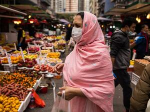 A woman wearing a protective face mask shops at a fresh food market in Hong Kong on February 9, 2020, as a preventative measure after a coronavirus outbreak which began in the Chinese city of Wuhan. AFP