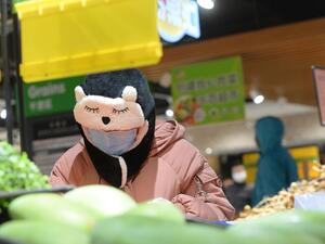 A customer wearing a protective mask shops at a supermarket in Wuhan, the epicentre of the outbreak of a novel coronavirus, in China's central Hubei province. The death toll from the novel coronavirus surged past 900 in mainland China on February 10, overtaking global fatalities in the 2002-03 SARS epidemic, even as the World Health Organization said the outbreak appeared to be stabilising. STR / AFP