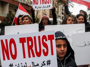 Anti-government demonstrators march with protest signs in the southern Lebanese city of Sidon on February 10, 2020, as they protest a day ahead of a parliamentary vote of confidence in the newly-formed government. Mahmoud ZAYYAT / AFP