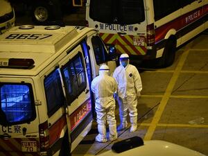Police officers wearing protective suits stand next to their vans in the ground of a residential estate, in Hong Kong, early on February 11, 2020, after two people in the block were confirmed to have contracted the coronavirus according to local newspaper reports. Anthony WALLACE / AFP