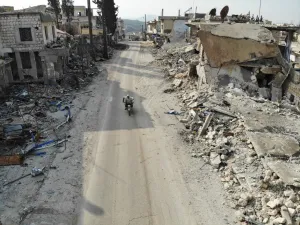 An aerial view taken on February 19, 2020 shows a man riding his motorcycle through destroyed buildings in the Syrian town of Ihsim in the southern countryside of Idlib. Omar HAJ KADOUR / AFP
