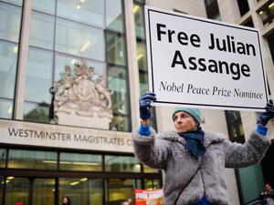 In this file photo taken on December 19, 2019, supporters of Wikileaks founder Julian Assange hold placards outside Westminster Magistrates Court in London. Tolga AKMEN / AFP