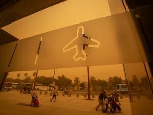 Passengers walk outside Tenerife South–Reina Sofia Airport during a sandstorm on February 23, 2020 on the Canary Island of Tenerife. Airports on Spain's Canary Islands were closed after strong winds carrying red sand from the Sahara shrouded the tourist hotspot.  DESIREE MARTIN / AFP