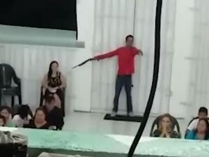 Police in the northwestern Brazilian city of Manaus are looking for two men, including one (pictured) who was caught on video pointing a gun at a woman inside a church Sunday night. (Video Screenshot)