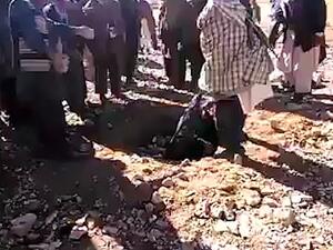 The woman appeared to be dumped in a pit before the stoning began. The punishment was frequently used against convicted adulterers when the Taliban ruled the country. (Video Screenshot)