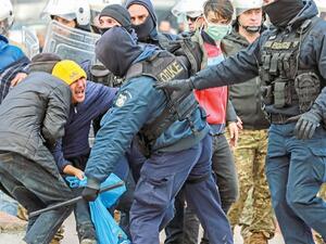 Riot police scuffle with migrants during a demonstration outside the municipal theatre of the city of Mytilene, on the island of Lesbos, on Tuesday. — AFP photo
