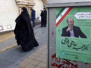 Extremists wanted. Iranians walk past an electoral poster of a candidate in the upcoming parliamentary elections on a street in Tehran on February 12. (AFP)