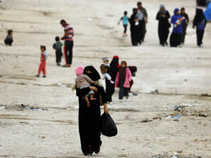People walk through Ain Issa, one of the camps that holds displaced Syrians as well as foreign wives of ISIS fighters and their children. AFP