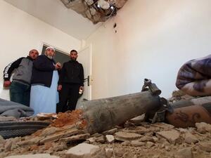 This picture taken on February 28, 2020 shows people inspecting the damage inside a building following a rocket attack by forces loyal to eastern Libyan strongman Khalifa Haftar, at a residential area in the government of national accord (GNA)-held capital Tripoli. AFP/File