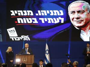 Israeli Prime Minister Benjamin Netanyahu addresses supporters as his wife Sara stands by, at the Likud party campaign headquarters in the coastal city of Tel Aviv early on March 3, 2020, after polls officially closed. Netanyahu claimed "a giant victory" in elections on March 3, boasting that his right-wing Likud party had defied "all expectations" in the country's third vote in less than a year. After exit polls by three networks forecast that Likud and its allies were on track to win 59 parliamentary seat