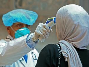 Kuwaiti health ministry workers scan employees and visitors of the ministries complex, as they arrive to their work, in Kuwait City on March 4, 2020. YASSER AL-ZAYYAT / AFP