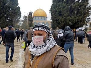 A Palestinian man wearing a protective mask as a measure of protection against the coronavirus COVID-19, stands in front of the Dome of the Rock mosque on the Temple Mount in the Old City of Jerusalem, ahead of the Friday prayers, on March 6, 2020. (Ahmad Gharabli/AFP)