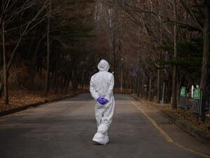 A health worker wearing a protective suit waits at a drive-through testing centre for the COVID-19 coronavirus in Seoul on March 7, 2020. South Korea has the biggest number of COVID-19 coronavirus cases outside China, with over 6,000 infections and 42 deaths, prompting the country to extend school breaks by three weeks. Ed JONES / AFP