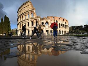 People pass by the Coliseum in Rome on March 7, 2020 amid fear of Covid-19 epidemic. Italy on March 6, 2020 reported 49 more deaths from the new coronavirus, the highest single-day toll to date, bringing the total number of fatalities over the past two weeks to 197. Alberto PIZZOLI / AFP