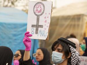An Iraqi woman holds a placard during a rally marking International Women's Day in the southern city of Basra on March 8, 2020. Hussein FALEH / AFP
