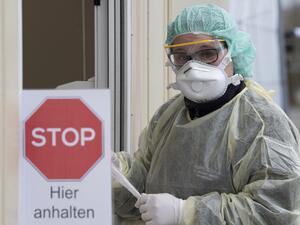 A medical assistant holds a test kit for the novel coronavirus SARS-CoV-2, which can cause COVID-19, at the new "Drive-In" in Nuertingen, southern Germany, on March 9, 2020, where people can get a coronavirus test from their car, during a presentation of the drive-in for the media. The number of coronavirus cases in Germany has passed 1,000, official data from the Robert Koch Institute disease control centre showed. THOMAS KIENZLE / AFP