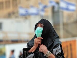 A woman, wearing a protective mask, looks at the nearly deserted Western Wall, Judaism's holiest site, after Israel has imposed some of the world's tightest restrictions to contain COVID-19 coronavirus disease, in Jerusalem on March 12, 2020. Israel imposed a two-week quarantine on all travellers entering the country, almost stopping tourism and limiting public gatherings as officials confirmed its 100th case of the COVID-19 coronavirus disease. Emmanuel DUNAND / AFP