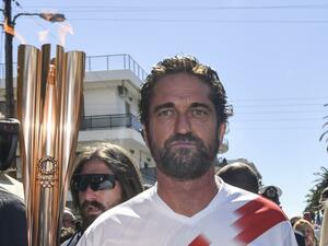 US actor Gerard Butler runs with the Olympic flame during the Olympic flame relay in Sparta on March 13, 2020 ahead of the Tokyo 2020 Olympic Games. Valerie Gache / AFP