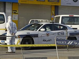Bahraini policemen seal off a building housing foreign workers in the Salmabad industrial area as a precautionary measure after a resident tested positive for coronavirus (COVID-19), on the outskirts of the capital Manama on March 13, 2020. Mazen Mahdi / AFP