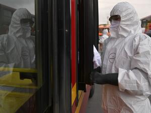 A worker washes and disinfects a bus at the bus station, as a measure to prevent the spread of the new Coronavirus, COVID-19, in Bogota, Colombia, on March 15, 2020. AFP/File