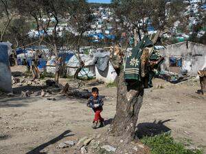 A young boy looks on as he walks at the unofficial camp net to the refugee camp of Moria in the island of Lesbos after a fire broke out, on March 16, 2020. Manolis Lagoutaris / AFP