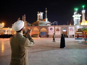A cleric prays outside the Fatima Masumeh shrine in Iran's holy city of Qom on March 16 2020. Iran closed four key Shiite pilgrimage sites across the Islamic republic on March 16 in line with measures to stop the spread of the new coronavirus, state media reported. State television said that "upon the orders of the anti-coronavirus headquarters and the health minister, the holy shrines of" Imam Reza in Mashhad, Fatima Masumeh in Qom and Shah Abdol-Azim in Tehran were closed until further notice. MEHDI MARIZ