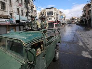 Soldiers from the Jordanian army patrol atop a military vehicle on a street in capital Amman during a nationawide curfew imposed by the authorities in order to control the spread of the novel coronavirus, on March 21, 2020. Khalil MAZRAAWI / AFP