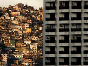 This file picture taken on September 27, 2017 shows a view of the Rocinha (L) favela seen behind a building of Sao Conrado neighbourhood, one of the richest areas of Rio de Janeiro. As the spread of the new coronavirus COVID-19 accelerates in Brazil, the poor populations crammed into the often unsanitary homes and precarious health services in the favelas, are on great alert. Mauro PIMENTEL / AFP