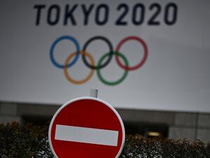 The Tokyo 2020 logo is pictured next to a "do not enter" street sign in Tokyo on March 23, 2020. CHARLY TRIBALLEAU / AFP