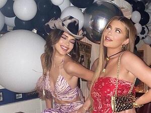 'Howdy': Kylie Jenner flashed her leg while posing with sister Kendall at her pal and former assistant Victoria Villarroel's birthday party on Thursday night (Instagram)
