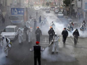 Iranian firefighters disinfect streets in a bid to halt the spread of coronavirus in Tehran on March 13. (AFP)