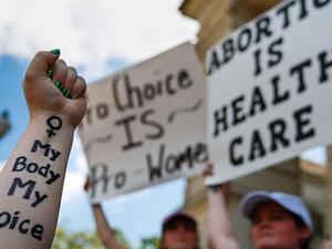 A protester holds up her arm with 'My Body My Choice' written on it during a protest against recently passed abortion ban bills at the Georgia State Capitol building [Elijah Nouvelage/Getty Images/AFP] 