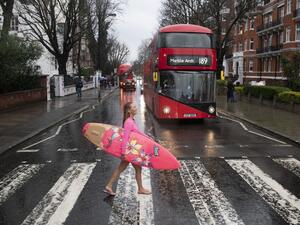 Hawaiian "protest surfer" Alison Teal recreates the famous Beatles Abbey Road album cover as she crosses Abbey Road during a visit to London on March 5, 2020, to raise awareness on the need to combat climate change. (AFP)