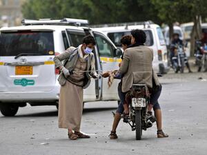 A Yemeni volunteer disinfects the hands of a man driving a motorcycle in the capital Sanaa, amid concerns over the spread of the novel coronavirus, on March 28, 2020. Yemen's broken healthcare system has not so far recorded a case of the COVID-19 illness, but aid groups have warned that when it does hit, the impact will be catastrophic in a country already regarded as facing the world's worst humanitarian crisis. Mohammed HUWAIS / AFP